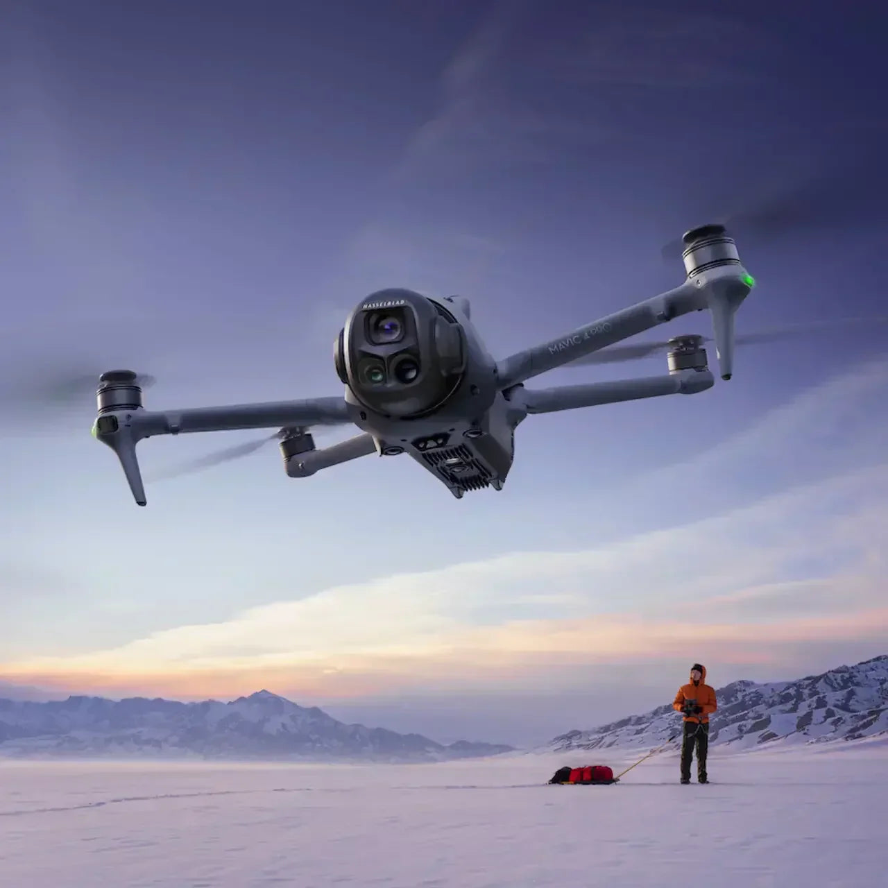 Mavic 3 Pro drönare flyger över snötäckt bergslandskap med person i orange jacka och utrustning